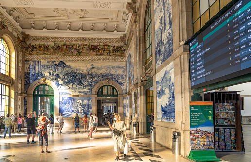 Porto, Portugal - People taking photos of the intricately decorated tiles in the entrance hall of São Bento, in central Porto.