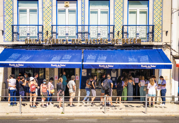 People queuing outside Pasteis de Belém bakery in Portugal Belém, Portugal - People waiting in line to get into Pasteis de Belém, a famous bakery in the town on Lisbon's outskirts, famed for the quality of its Pastels de Nata. pasteis de belem stock pictures, royalty-free photos & images
