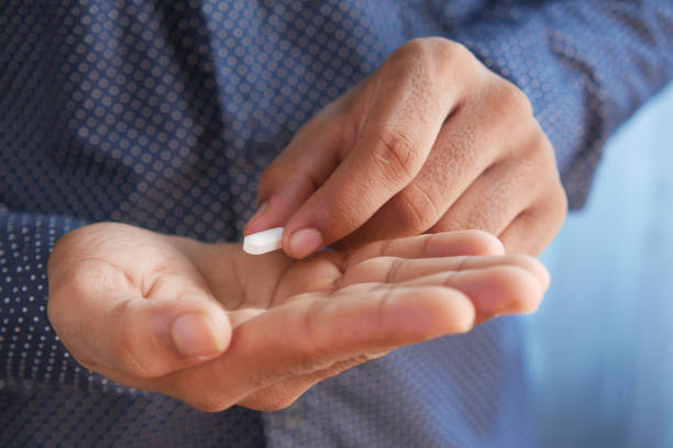 istock Close up of man hand holding pills with copy space 1344090438