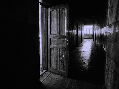 an open door and a corridor in an abandoned building
