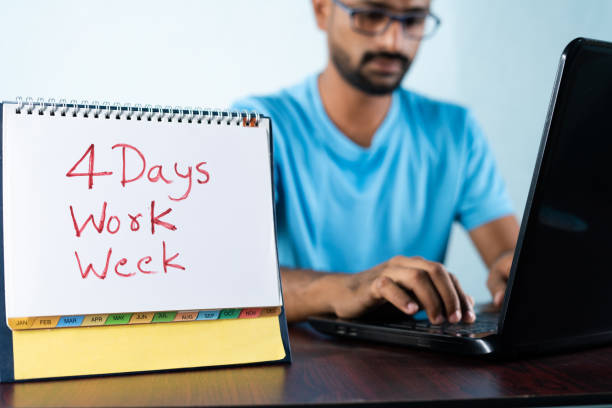 focus on calendar, concept of four or 4 days work week showing by young man working in background and shows calendar - week imagens e fotografias de stock