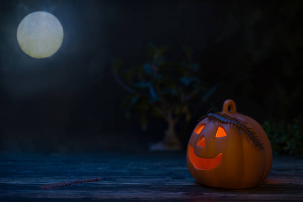 istock Halloween background with illuminated pumpkin at night 1344091912