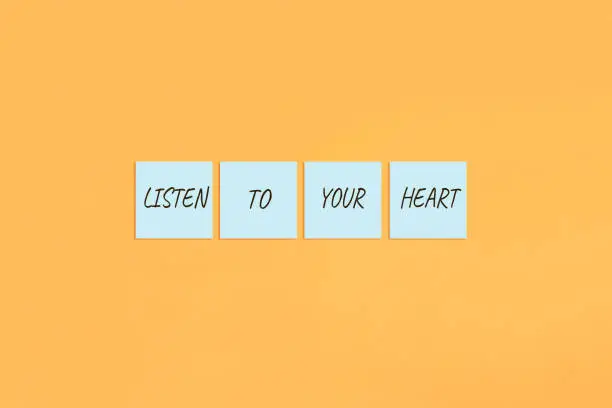 Motivational quote Listen to your heart. Handwritten inscription on sticky notes.