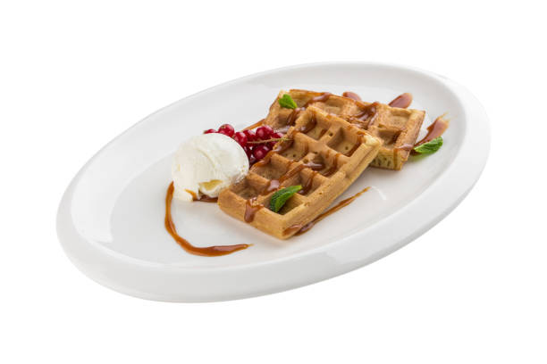 istock Belgian waffles with ice cream, caramel sauce and red currant isolated on white background 1344094473