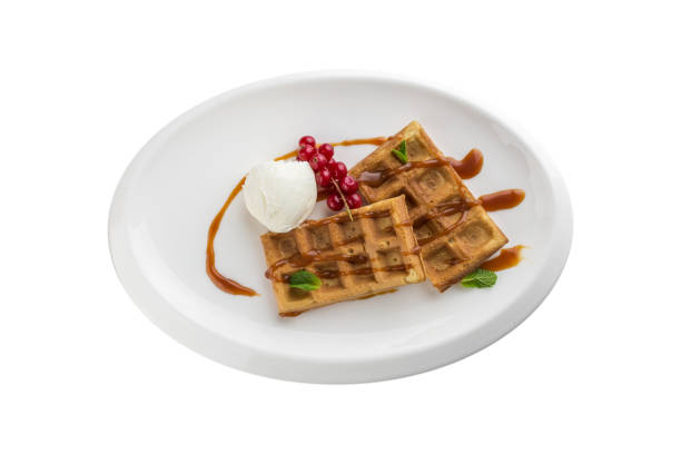 istock Belgian waffles with ice cream, caramel sauce and red currant isolated on white background 1344094483