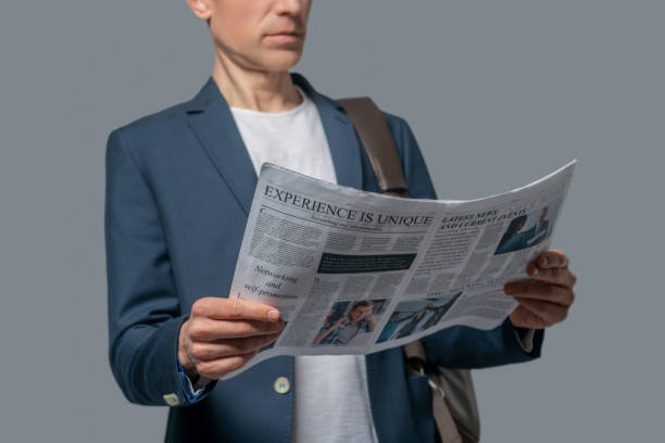 Man with newspaper in hands reading news