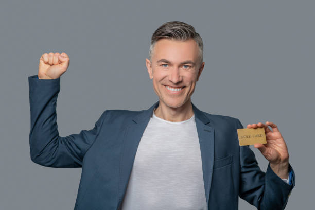 istock Man with credit card raising his hand victoriously 1344096584