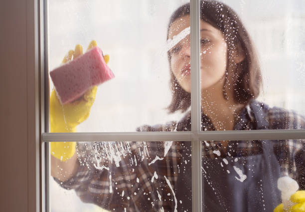 istock Woman washes the windows with a detergent. 1344100614