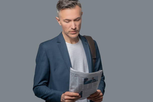 istock Serious business man looking at newspaper 1344101007