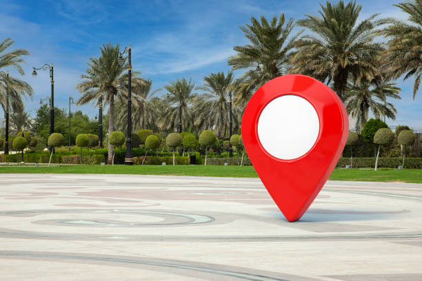 istock Red Map Pointer Pin in Empty City Street with Palm Trees. 3d Rendering 1344101128