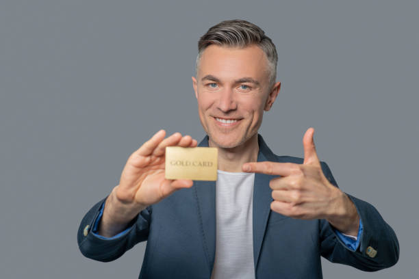istock Cheerful confident man pointing at credit card 1344102512