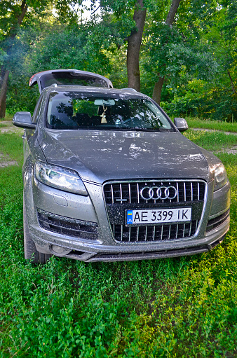 Novomoskovsk, Ukraine 06/21/2021. Large SUV Audi Q7 large mixed forest on vacation.