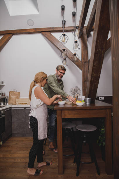 istock Mature married couple preparing food in their modern kitchen 1344106057