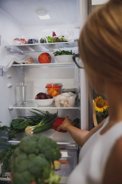 istock Woman packing vegetables in the fridge 1344107078