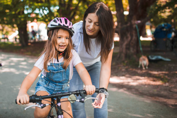 istock Mother teaches her daughter to ride a bicycle 1344109021