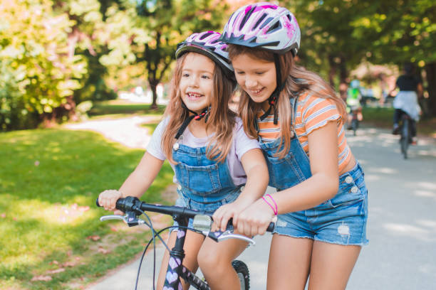 istock Sisters have fun and learn to ride a bike 1344109131