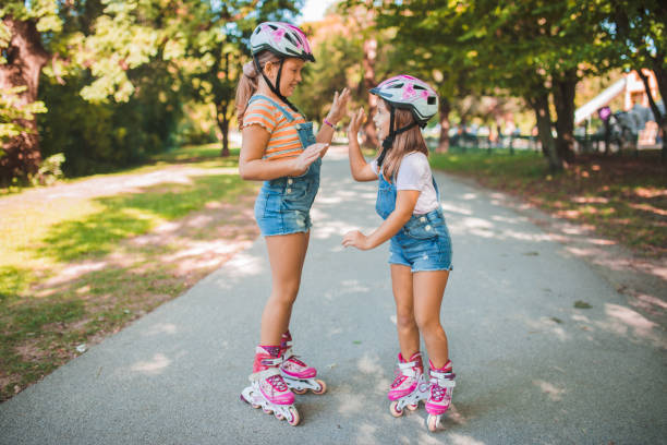 istock Sisters give each other hige-five, they are ready to ride rollerblades 1344109714