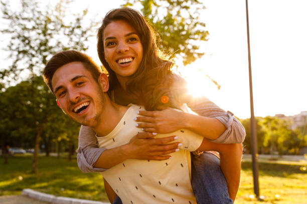istock Cheerful young couple doing a piggyback ride while going on a park walk 1344109808