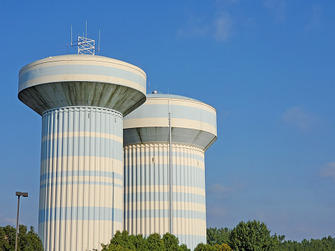 A low angled photograph of a grey colored water tower in Nightcliff, Darwin, showing the structural engineering informing the struts and bracing capable of supporting a full water tank.