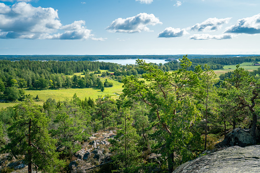 Beautiful summer day in Swedish landscape of Segersgarde nature reservation. Green forests, meadows view from the top of the rock. Summer holiday in Sweden