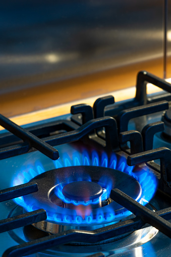Gas burners with blue flame on black background.