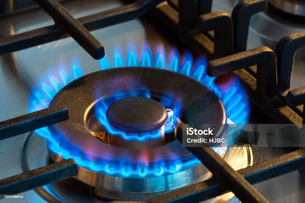 Gas burning with blue flames on the burner of a gas stove Gas burning with blue flames on the burner of a gas stove. Concept of carbon footprint and price of natural gas on the market Natural Gas Stock Photo