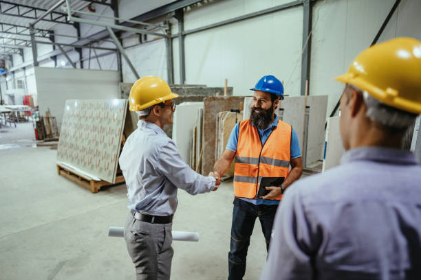 istock Manager and engineer shaking hands in factory 1344121358