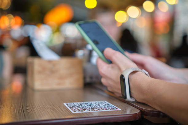 istock Closeup of guest hand ordering meal in restaurant while scanning qr code with mobile phone for online menu. 1344121366