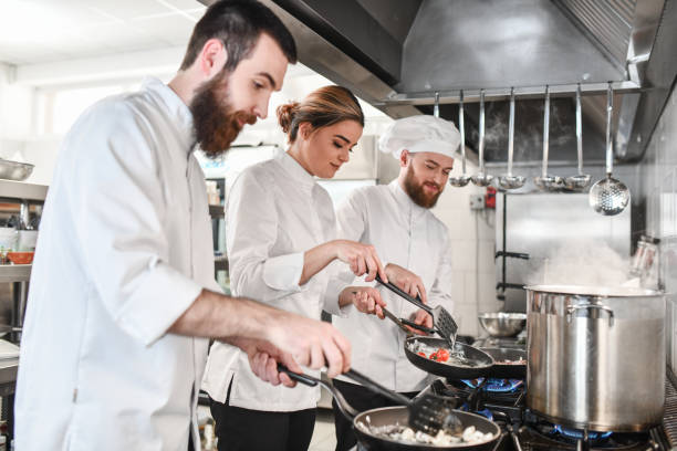 istock Female Cook Getting Instructions From Chef On How To Fry Vegetables 1344122200