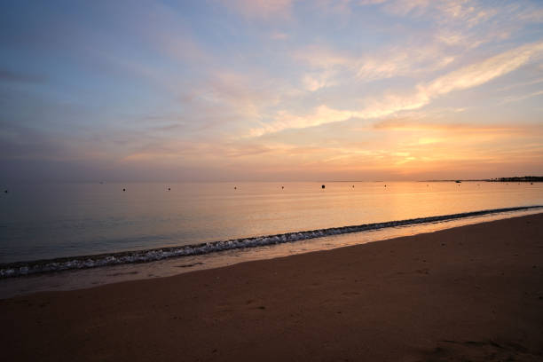 istock Calm sea shore with crushing waves on sandy beach at sunrise. 1344123752