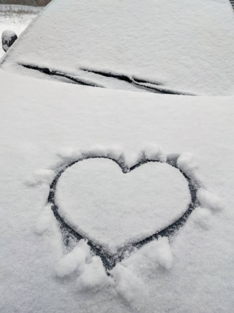 istock close up on drawing hearts on car windshield after snow 1344126470