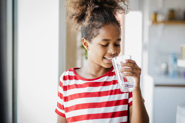 urocza dziewczyna pijąca wodę - glasses child little girls african ethnicity zdjęcia i obrazy z banku zdjęć