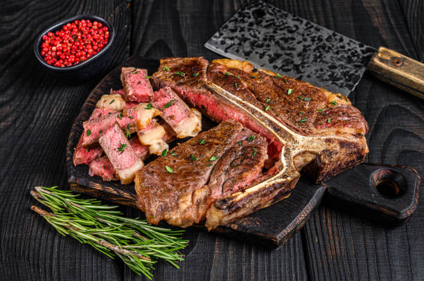 sliced and roast t-bone or porterhouse beef meat steak for steakhouse menu. black wooden background. top view - red meat meat dish grilled rare imagens e fotografias de stock