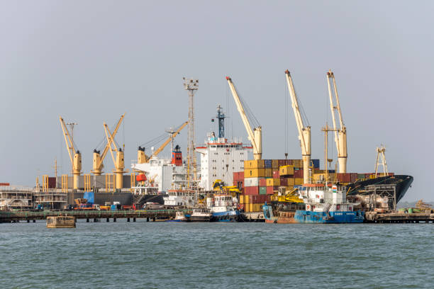 Port of Banjul Banjul, The Gambia - May 07, 2017: Cranes boats and containers in the commercial port of the city banjul stock pictures, royalty-free photos & images