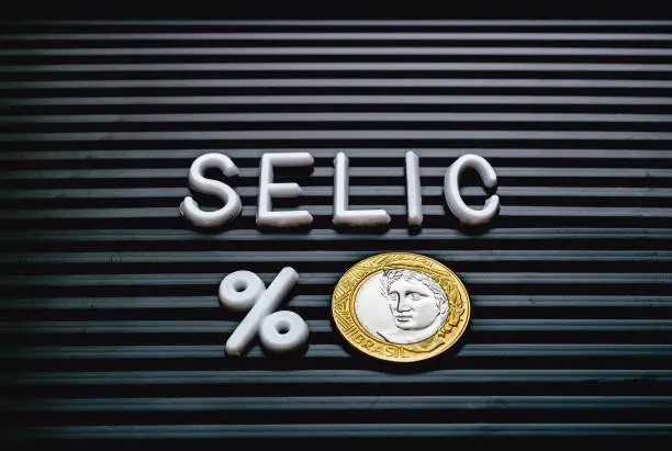 Word Selic formed on a board with letters and a 1 Real coin. Brazilian economy.