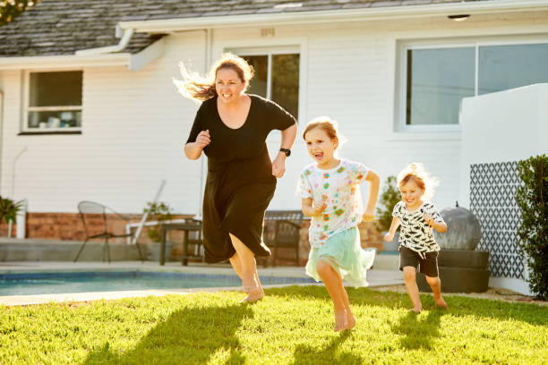 istock Mother and children playing together in their backyard 1344132300