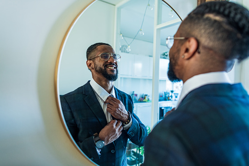Young businessman motivates himself in front of a mirror