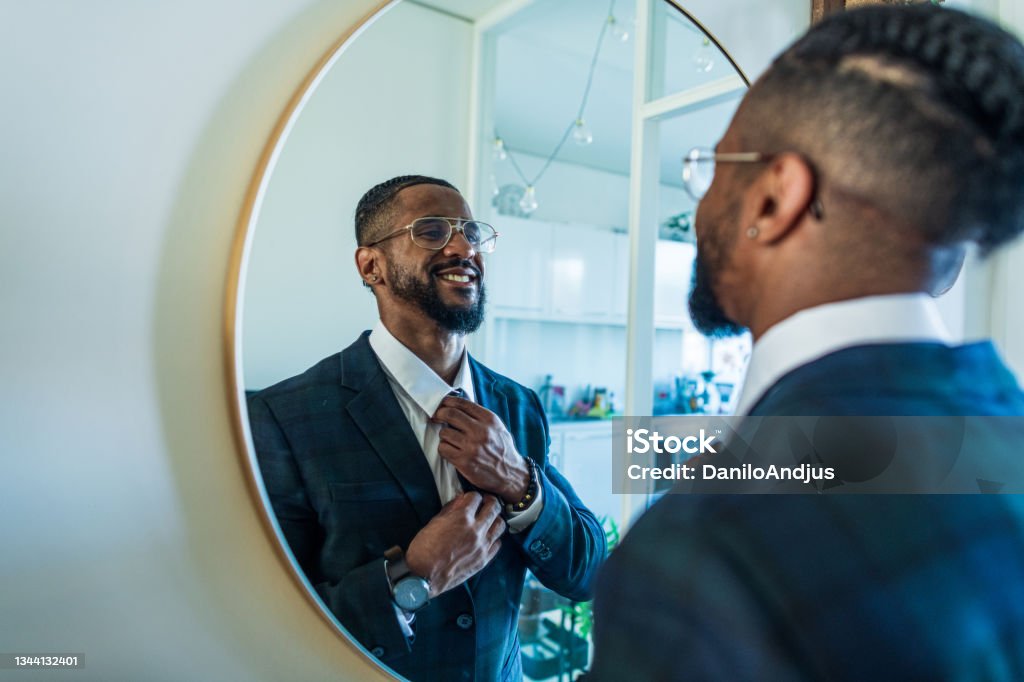 Young businessman motivates himself in front of a mirror Portrait of an elegant man in a suit preparing for an important day at work Mirror - Object Stock Photo