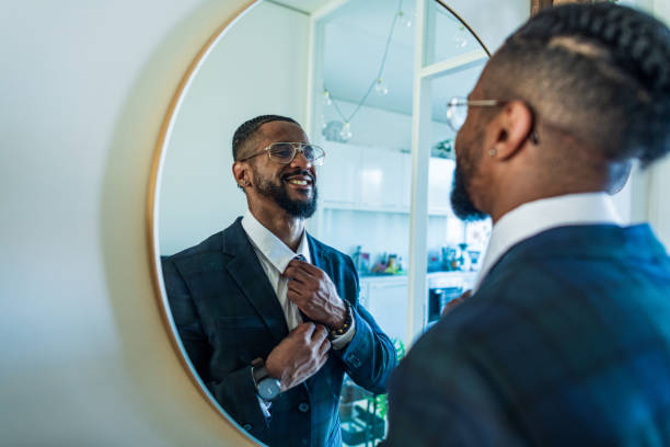 Young businessman motivates himself in front of a mirror stock photo