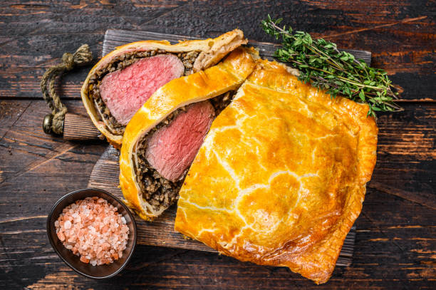 tarta de hojaldre casera beef wellington con carne de solomillo en tabla de cortar. fondo de madera oscura. vista superior - top sirloin british cuisine sirloin steak roast beef fotografías e imágenes de stock