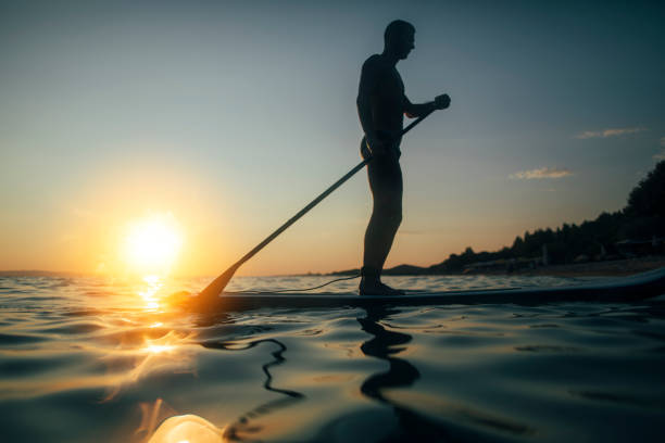 istock Man paddleboarding on a sunset sea 1344135173