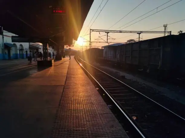 Sunrise at the glowing railway station due to rays