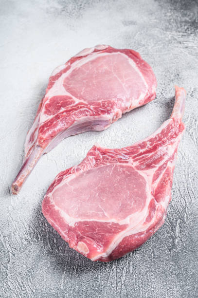 istock Raw dry aged tomahawk pork chop steak. White background. Top view 1344136735