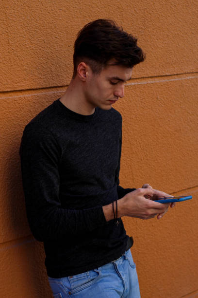 istock vertical picture of young guy with mobile 1344138841