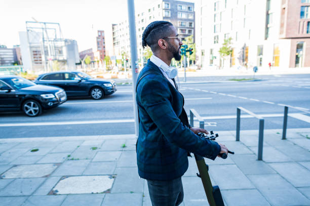 istock Elegant man rides an electric scooter 1344141408