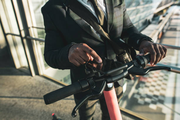 istock Elegant man setting up his phone on his electric scooter 1344143500