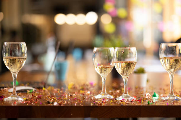 Business office new year's party and celebrations Close up focus on foreground of the empty business office new year's after party mess with laptop and drinks on the dirty table covered in confetti after party stock pictures, royalty-free photos & images