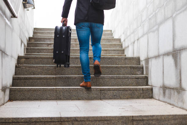 istock White young businessman going up the stairs while carrying a suitcase and wearing a backpack 1344144705