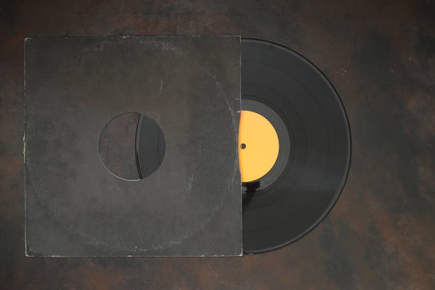 istock Aged black paper cover and vinyl LP record isolated on rusty background 1344144729