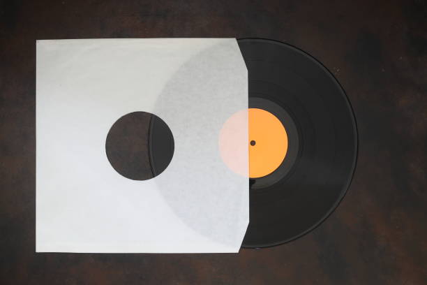 istock Aged White paper cover and vinyl LP record isolated on rusty background 1344144815